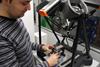 Eponsa Anwenderbericht - Ein Eponsa Techniker lädt ein Teil eines Wischermechanismus auf das Equator Prüfgerät